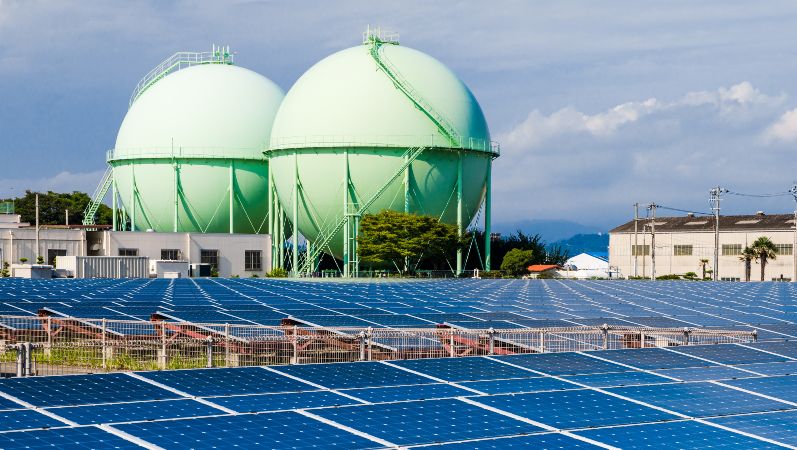 Photovoltaikanlage, Solarzellen, Gasbehälter und Stromnetzleitungen