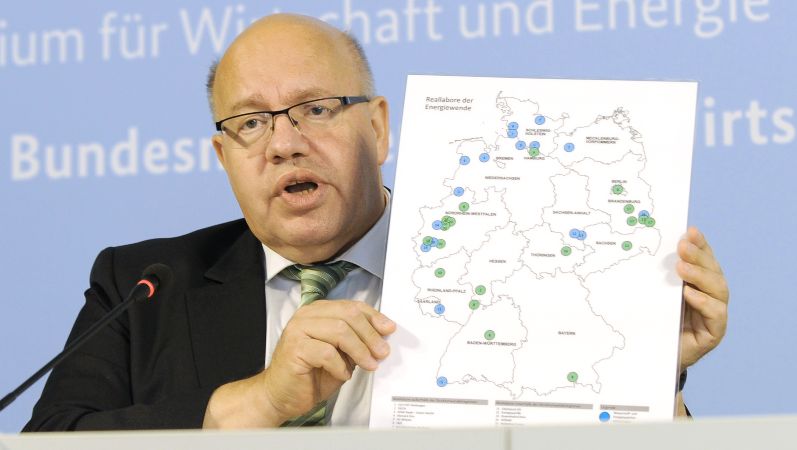 Minister Peter Altmaier hält eine Deutschland-Karte mit den Gewinnern des Ideenwettbewerbs hoch